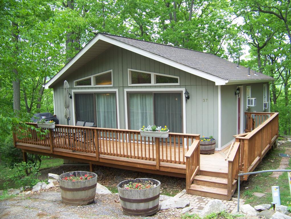 Completely remodeled,  open &amp; bright, larger than it looks.  Nestled up to the woods, backs to a nature preserve.  See add'l. comments... New kitchen and baths,new carpeting and hardwood floors,freshly painted, newer wrap around deck, new masonry chimney, new Anderson Low E Atrium doors on both levels, new front door with lead glass insert, vaulted ceiling in Living Rm, Dining Rm. &amp; Kitchen,  finished walk-out lower level includes Family Room with dramatic stone wall with wood stove for heating efficiency,  new roof (30 year warranty) and much more!  Beautiful views, public water and sewer, community pool and recreation area.  Minutes to Ken Lockwood Gorge and 8 min. to Rte. 78.