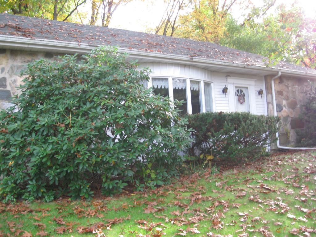Spacious Stone Ranch with a park-like setting on a 1/2 Acre. Oversized 2 car garage, C/A, 2 1/2 baths, sunroom,  lg LR w/FP, roof new 2006, full finished bsmt w/woodstove. Lovely gazebo. Must be seen! Den could be used as a bedroom. Finished basement has a half bath that could easily accommodate a shower. Enjoy the great 3 Season Room/Sunroom off the kitchen.