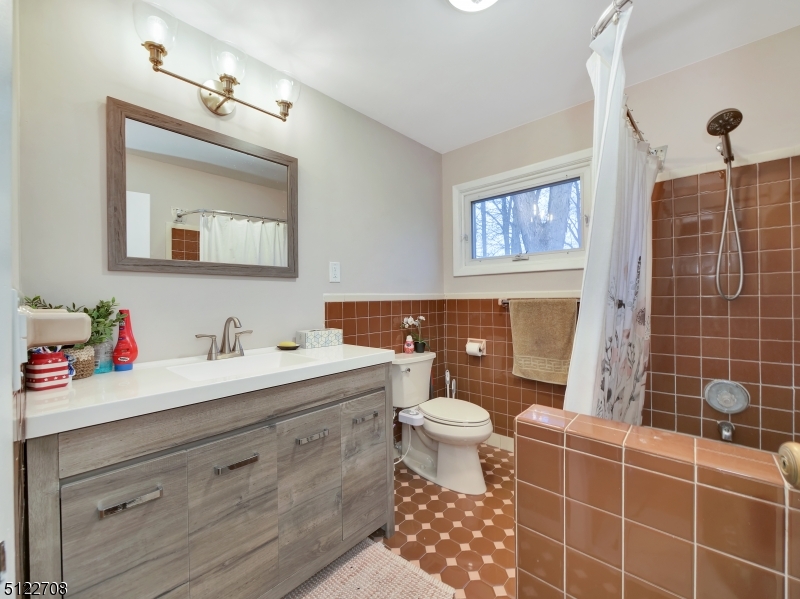 The main bathroom offers storage vanity and stall shower.