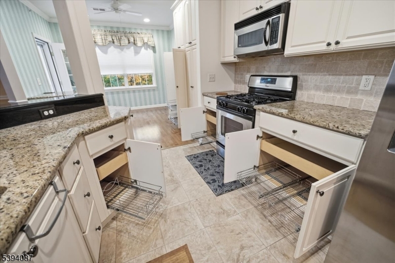 Kitchen Featuring extended length cabinets with custom pull out lower drawers, granite counter tops and SS appliances