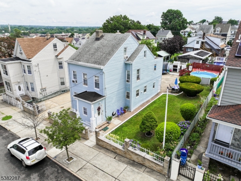 Charming curb appeal with fenced yard, manicured landscaping, and a long driveway leading to multiple parking spaces and garage.