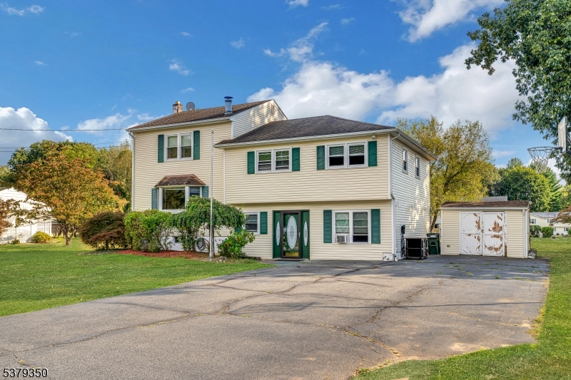 The inviting front view highlights a spacious driveway. Perfectly situated in a desirable neighborhood, this home combines style, function, and convenience.