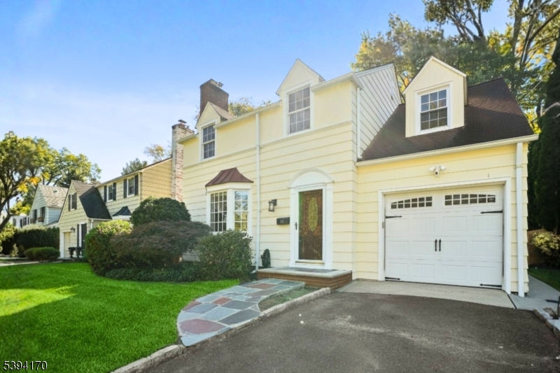 Front Classic Colonial curb appeal with manicured landscaping, private driveway, and attached garage.