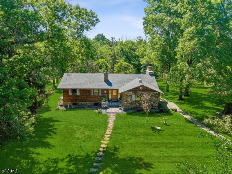 Log Cabin Home with extensive Stone work, sited on 22+ acres with a 2-acre pond affording privacy, and a peaceful, tranquil setting.