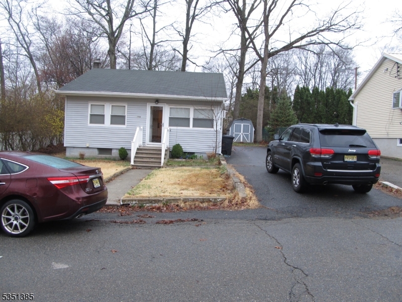 front of property with driveway and shed in back