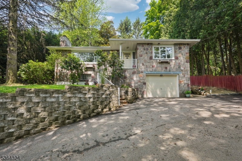Tucked away on a beautiful, private wooded lot, discover this charming stone Ranch.