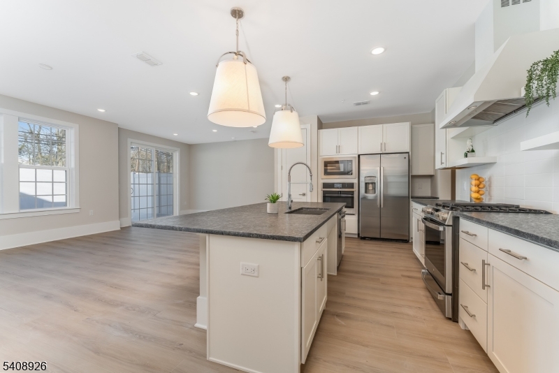 View Sun-drenched designer kitchen featuring an expansive island, premium stainless-steel appliances, and an elegant open layout ideal for both everyday living and entertaining.