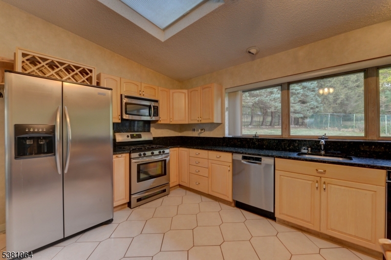 kitchen Kitchen has wood cabinets, counters and stainless steel appliances.