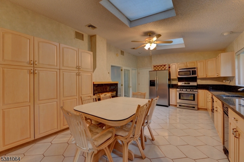 eat-in kitchen Kitchen has a wall of cabinets for storage.
