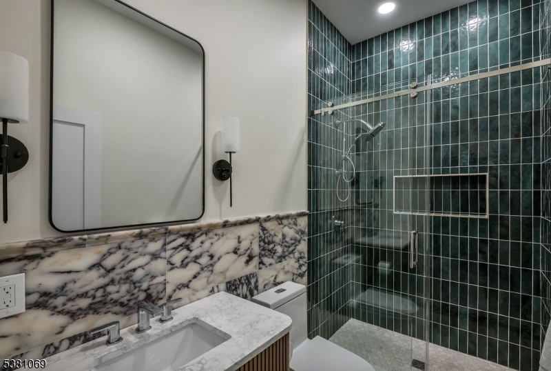 Bathroom Full Bathroom with Marble Accents Located Off of the Mudroom and Garage Area