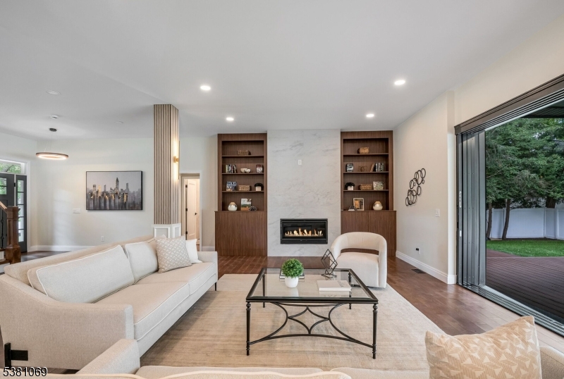 Living Room Stylish Living Room with a Porcelain Accent Wall, Gas Fireplace, and Custom Built -In Shelves