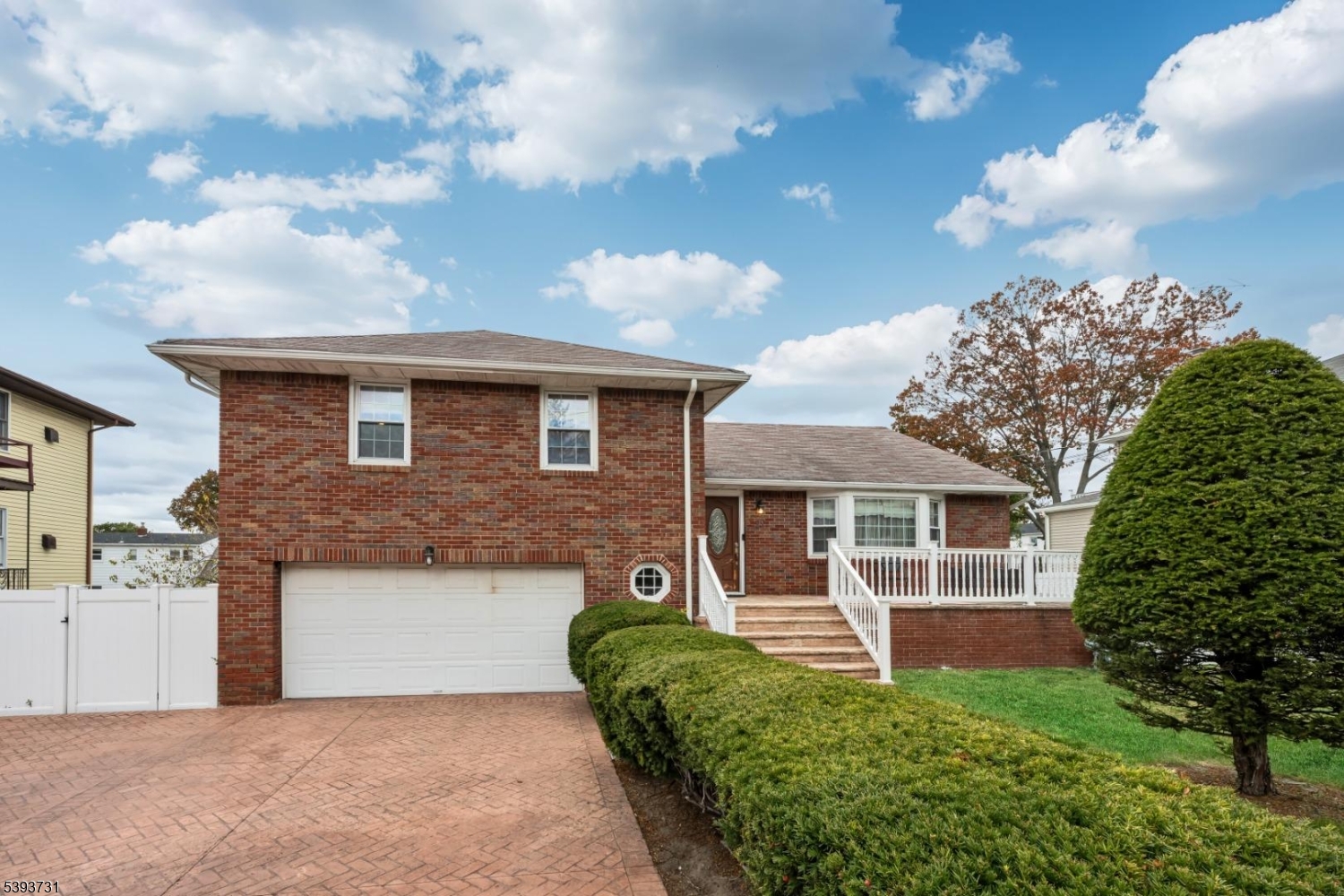 Front Charming brick exterior with a spacious stamped concrete driveway and attached garage. The inviting front porch and manicured landscaping set the tone for this well-maintained home.