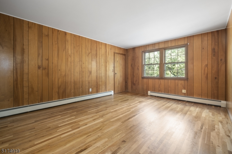 Paneled den/office or library with interior access to garage. Plenty of book shelves and gorgeous hardwood floors.