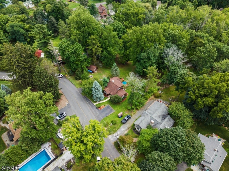 Ariel Above Set on 1.26 private, beautifully landscaped acres, this one-of-a-kind retreat is surrounded by mature trees, rolling grounds, gardens, a gazebo, deck, patio, and two driveways with parking for 5+ vehicles.
