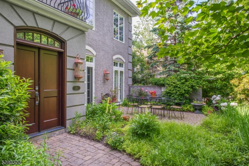 Garden lined entrance with paver block walkway to double wood doors opening to breathtaking, formal foyer.