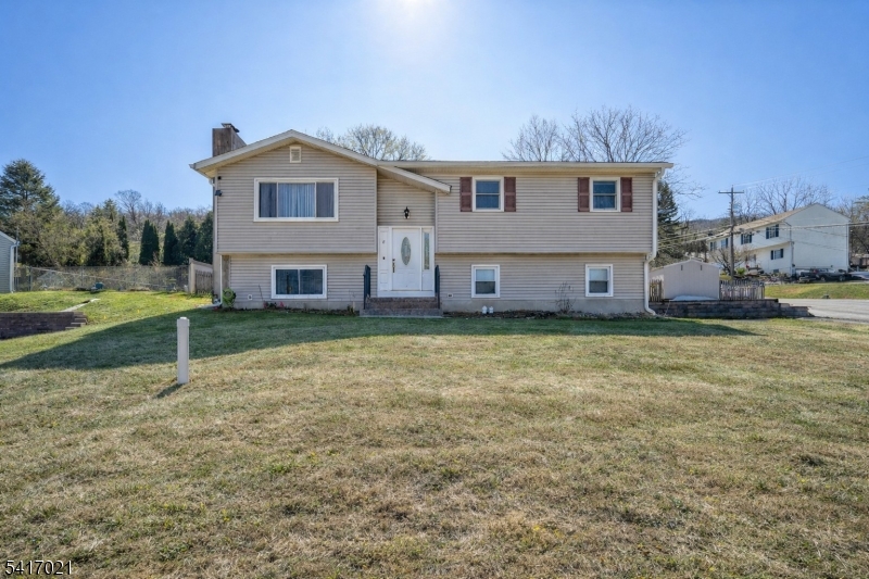 FRONT VIEW OF HOME SET BACK FROM THE ROAD, VINYL SIDING AND LARGE DRIVEWAY ON SIDE. (brand new septic system) so grass is virtual.