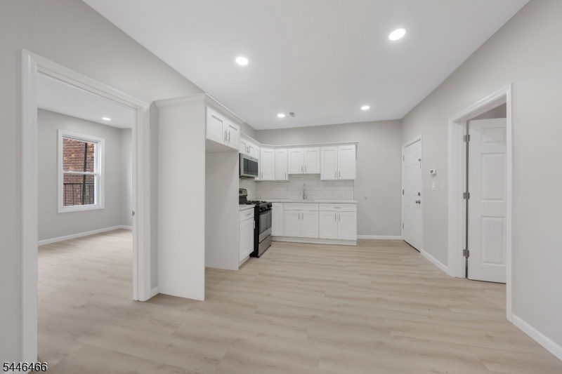 Kitchen Open kitchen with white cabinetry, stainless appliances, and flow into living area.