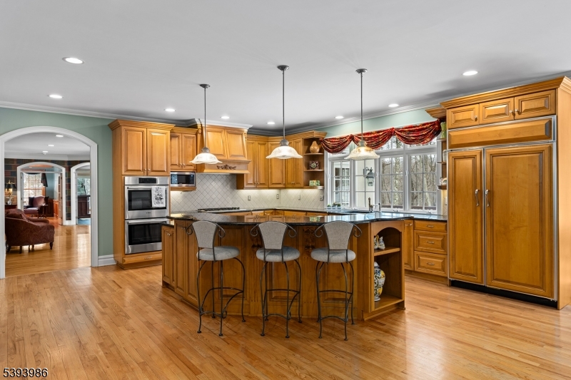 Kitchen Hardwood Floors, Large Center Island w/ Seating, Walk-in Pantry, Custom Cabinetry, and Granite Counters