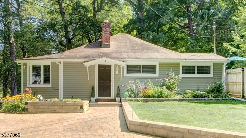 Pretty landscaped entrance with paver driveway and walkway to separate lower level entrance