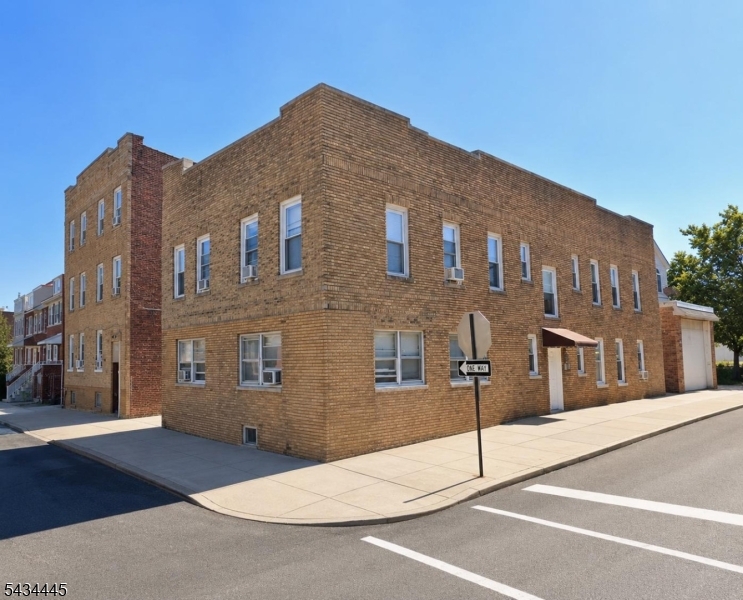 Outside Building View Classic low-rise brick apartment building with a corner-lot presence, clean exterior view, and convenient Passaic location.