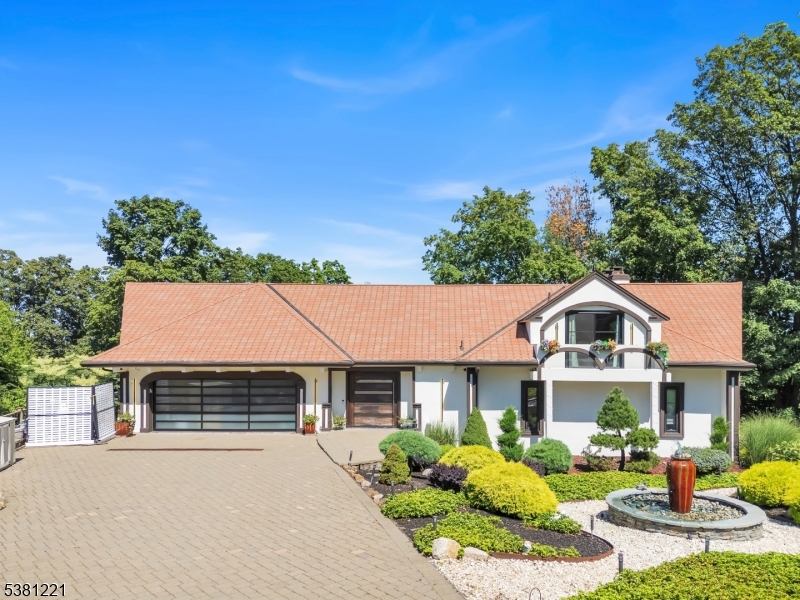 Front of House This stunning custom home is nestled at the end of a cul-de-sac & the wow factor happens from the approach w/incredible Japanese specimen & ornamental landscape design, water feature, custom Paver driveway, sleek & purposeful detailed lighting & more!