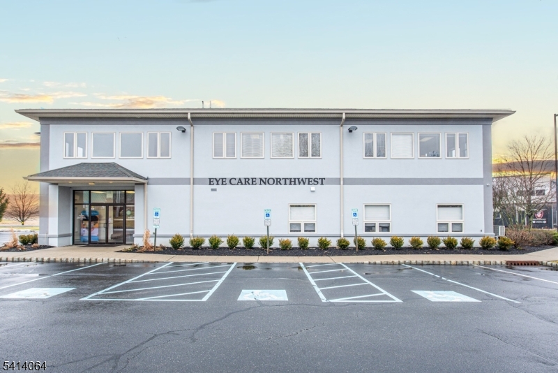 Front exterior elevation featuring professional faÃƒÂ§ade, prominent signage, and dedicated accessible parking spaces.