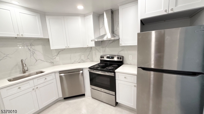 Kitchen Kitchen updated last year with new flooring, lighting, All-new cabinetry, tiled backsplash and flooring, quartz countertops, and modern chrome-hued appliances.