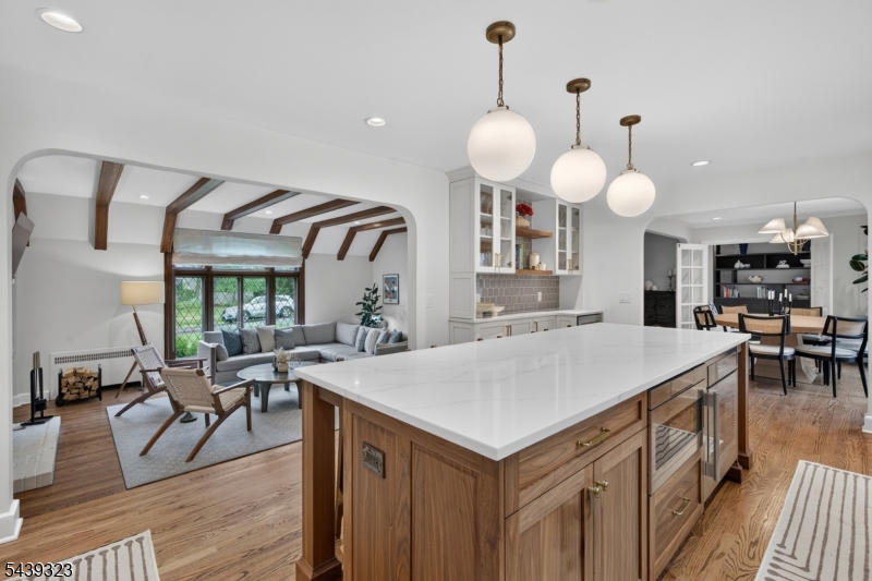Renovated chef's eat-in Kitchen with crisp white shaker styled cabinetry with storage, quartz countertops, marble backsplash. high-end Thermador stainless appliance, enormous center island
