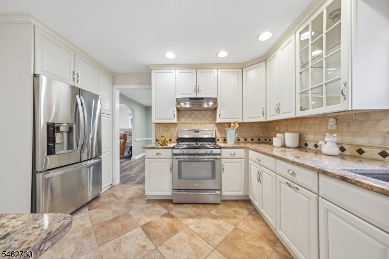 Stainless steel appliances and sink, tile backsplash, recessed lights