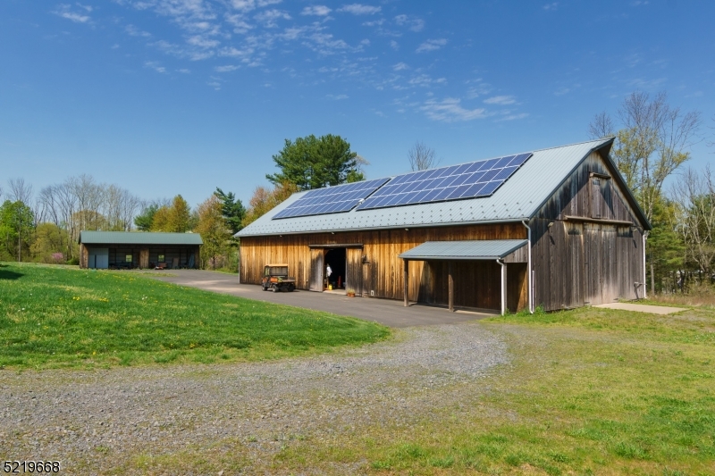 Solar panels on barn and equipment shed in background