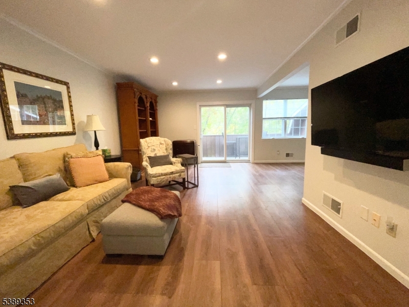 The Spacious Living Room features wide plank wood style laminate floors for beauty and convenience and finely finished in soft grey walls and white moldings. Peaceful woodland views are offered from every window.