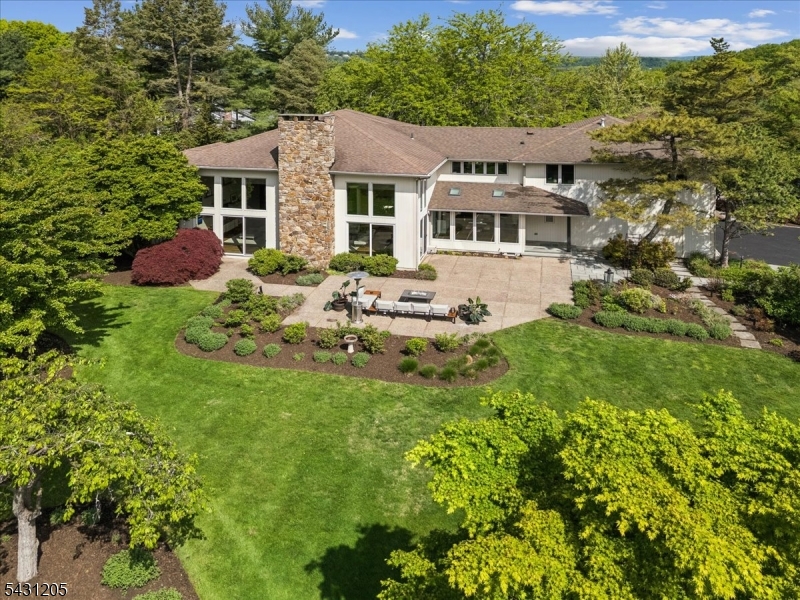 Aerial View Aerial rear view showcasing the expansive patio, lush landscaping, level lawn, and private estate setting