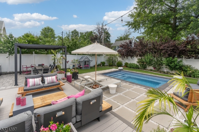 Backyard complete with pool, deck, and kitchen