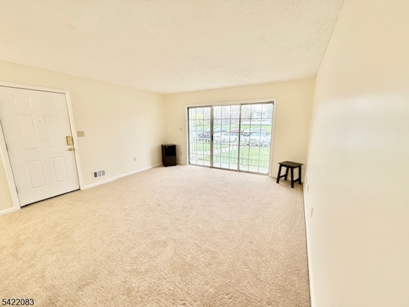 Spacious carpeted living room with window view