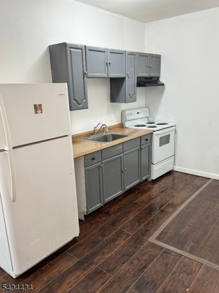 Functional kitchen featuring a refrigerator and sink.