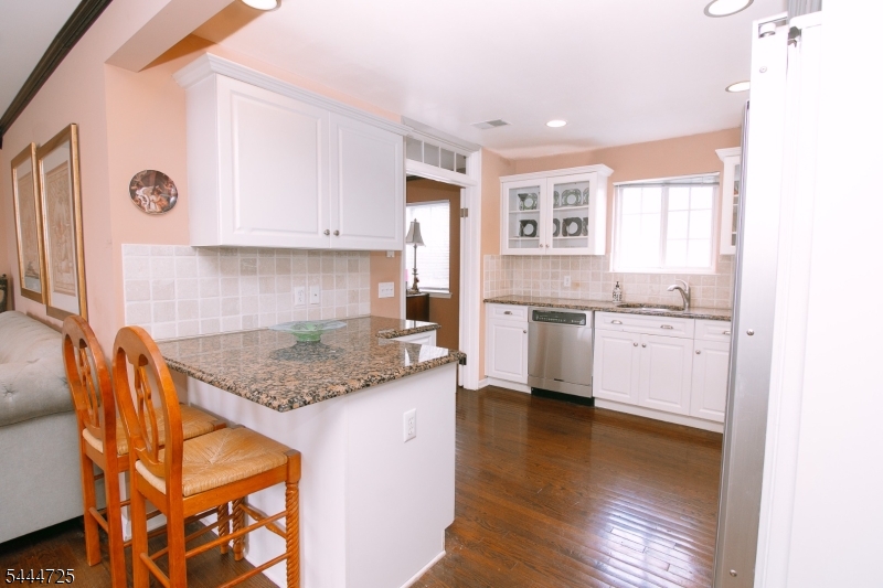 Bright eat-in kitchen featuring granite countertops, abundant cabinetry, quality appliances, and hardwood floors. A welcoming space designed for everyday living, casual dining, and effortless entertaining in Berkeley Heights.