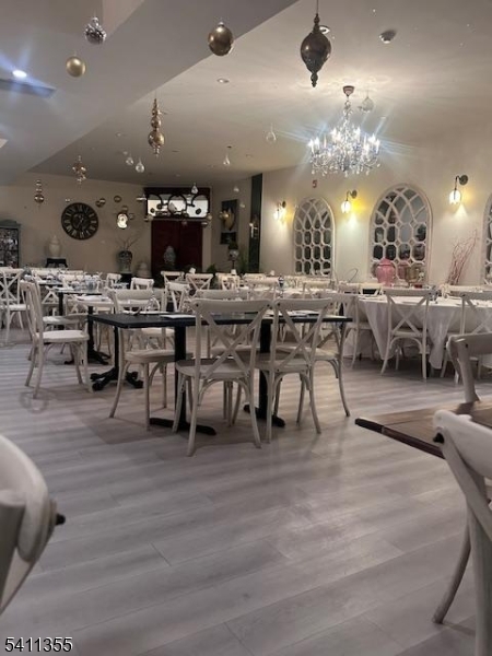 Elegant open dining area with spacious layout, chandelier lighting, and decorative accents. Flexible seating accommodates private parties and events, creating a warm, upscale atmosphere ideal for dining and special occasions.