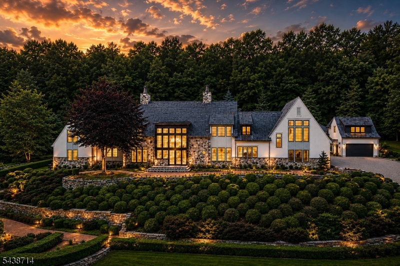 The warm interior light, glowing gas lanterns, and beautifully lit grounds create an unforgettable evening presence that defines luxury country estate living.