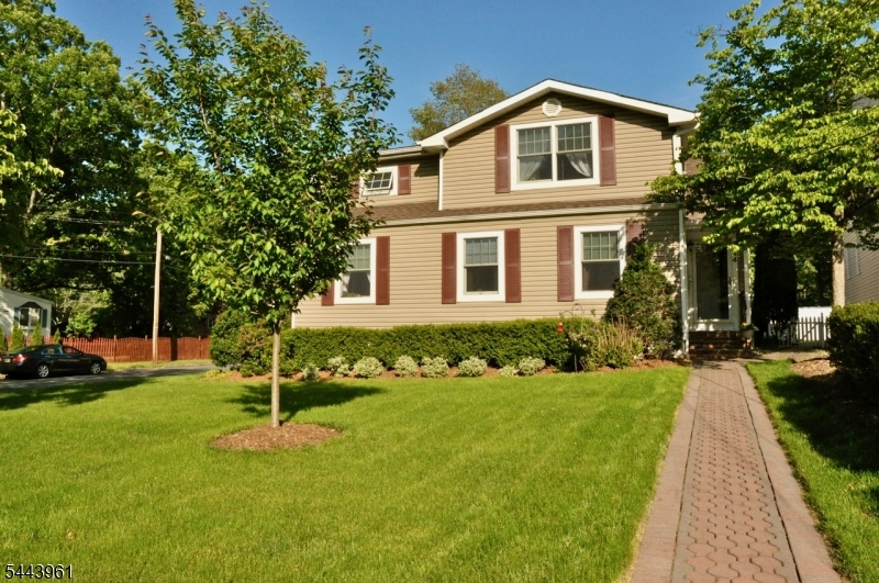 Front View Beautifully maintained home with outstanding curb appeal, highlighted by a lush, manicured lawn, mature shade trees, attractive landscaping, and a charming paver walkway leading to the welcoming covered front entrance.
