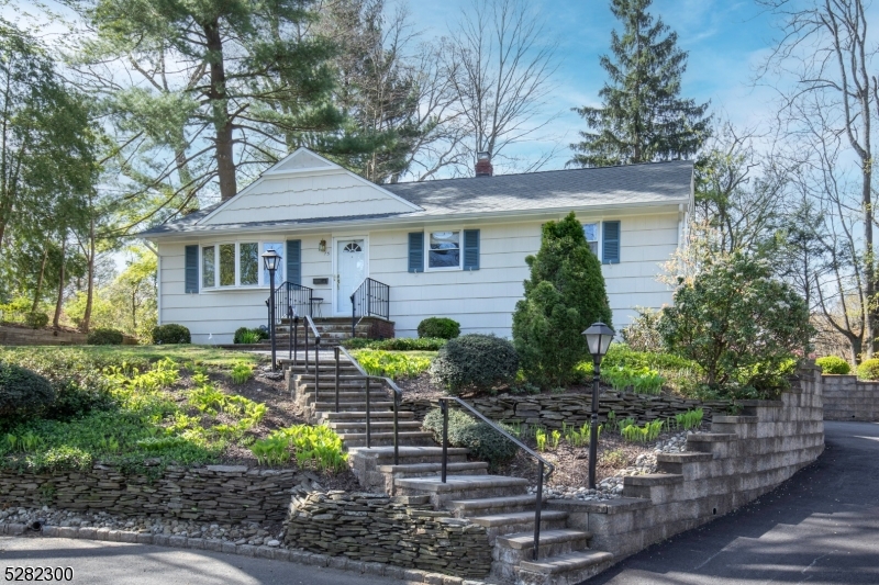 This wonderful Colonial-style home has been lovingly cared for. A handsome stacked stone wall accents the front yard.