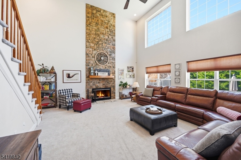 Fabulous room with soaring ceilings and abundant natural light. The dramatic stone facade and fireplace are impressive and perfect for everyday living and gatherings.
