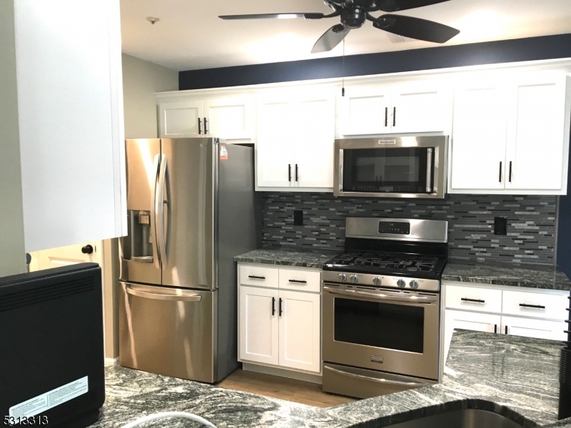 A completely modern kitchen with stainless steel appliances, granite countertops, high-performance appliances and plenty of stylish, wood cabinets.