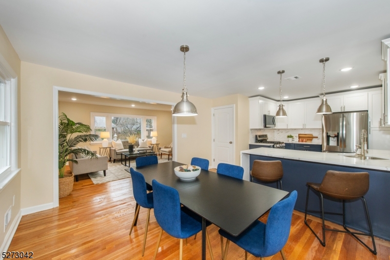 The inviting dining room opens freely to both the kitchen and the living room. The dining room has new contemporary lighting, tons of sunlight and refinished floors.