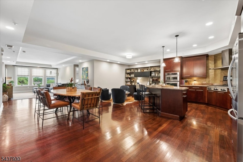Main Area Open Area Open-concept kitchen, dining, and living space featuring rich hardwood floors, custom built-ins, and abundant natural light.