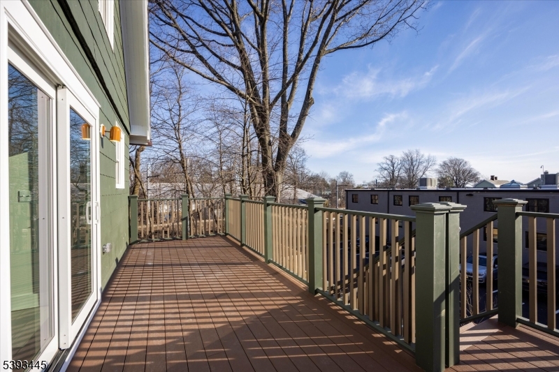 Balcony directly adjacent to the kitchen with stairs to parking lot and side yard