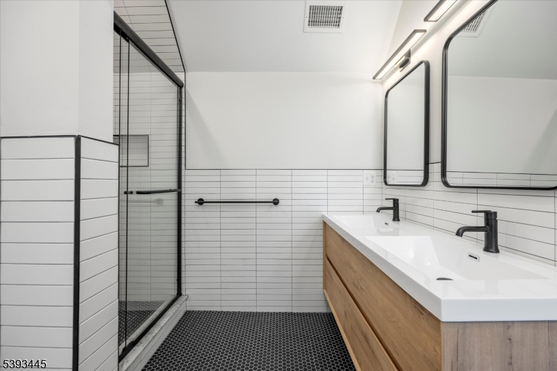 Primary Bathroom view 2 stall shower and double vanity