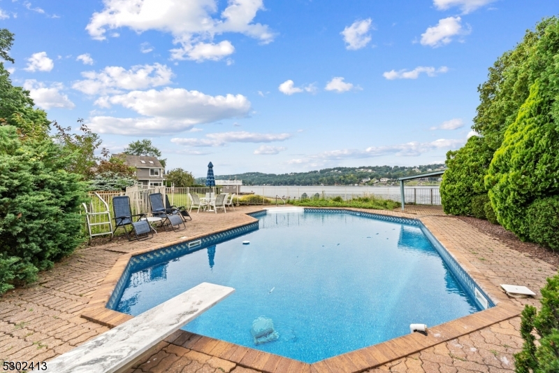 Pool with diving board and pavers.