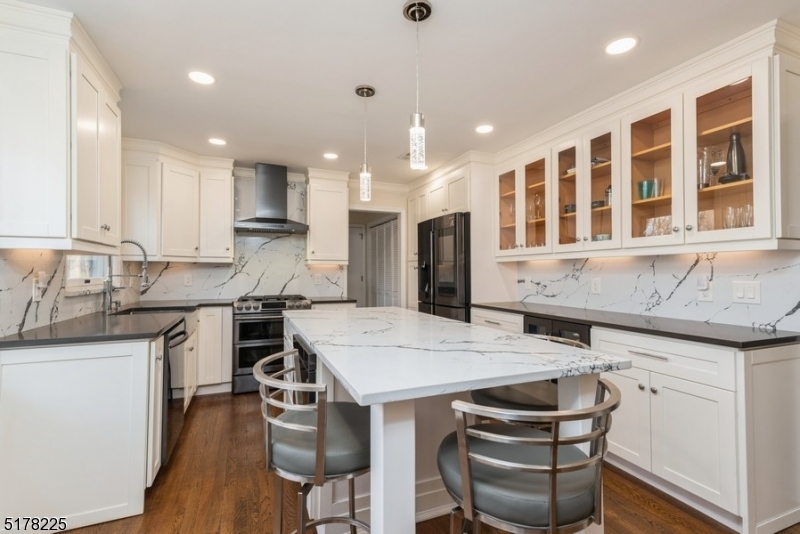 Updated eat-in kitchen features Quartz counters and backsplash, Stainless Steel appliances, pantry and crisp white bright cabinetry.