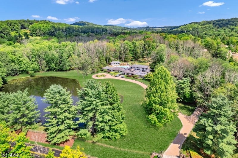 8 acres of paradise!   2 acre pond and lighted gazebo greets you as you arrive.   Heated pool and spa, fenced dog run, additional 3 car detached garage