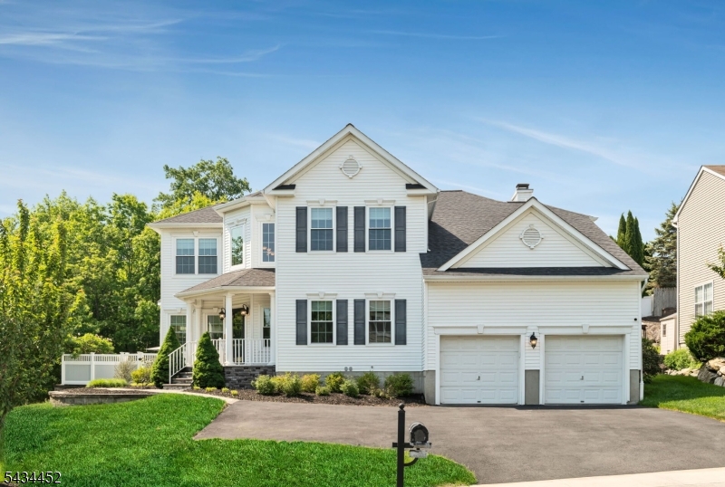 BEAUTIFULLY SITUATED COLONIAL Perched on a corner property surrounded by the beauty of nature in abundance. Oversized heated driveway can accomodate 6 cars in addition to the 2 car garage...never a parking issue here!